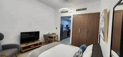 a living room with a bed and a flat screen tv at Shaista Azizi Residence - Al Furjan by Golden Casa in Dubai