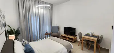 a bedroom with a bed and a desk and a television at Shaista Azizi Residence - Al Furjan by Golden Casa in Dubai
