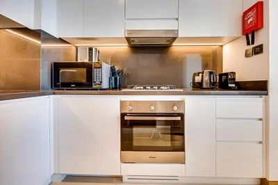 a kitchen with white cabinets and a microwave at Breathtaking views from Vida Dubai Marina in Dubai