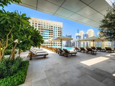 a patio with chairs and umbrellas and a pool at Breathtaking views from Vida Dubai Marina in Dubai