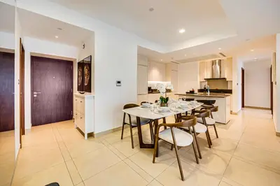 a kitchen and dining room with a table and chairs at Panoramic canal views from brand new 3BD apartment in Dubai