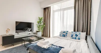 a living room with a bed and a tv at Upgraded 1BR Apartment in Bloom Tower B - JVC in Dubai