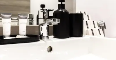 a sink with a faucet and two bottles on it at Upgraded 1BR Apartment in Bloom Tower B - JVC in Dubai