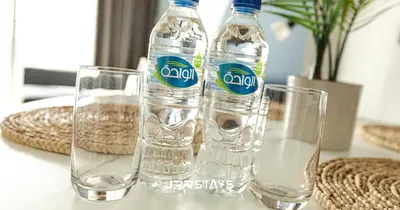two bottles of water and two glasses on a table at Upgraded 1BR Apartment in Bloom Tower B - JVC in Dubai