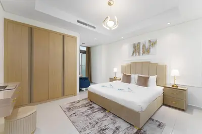 a bedroom with a large bed and a desk at Experience Opulent Living at Paramount Midtown in Dubai