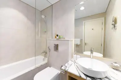 a bathroom with a sink and a toilet and a tub at Experience Opulent Living at Paramount Midtown in Dubai