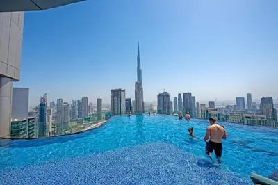 a man in a swimming pool on top of a skyscraper at Experience Opulent Living at Paramount Midtown in Dubai