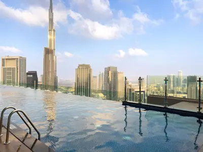 a pool on the roof of a building with a city skyline at Experience Opulent Living at Paramount Midtown in Dubai