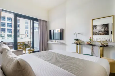 a hotel room with a bed and a large window at Frank Porter - Riviera 26 in Dubai