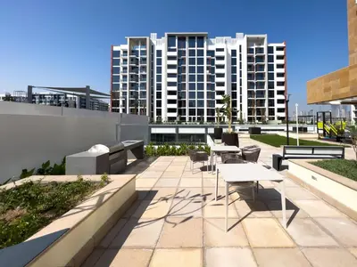 a patio with tables and chairs and buildings at Frank Porter - Riviera 26 in Dubai