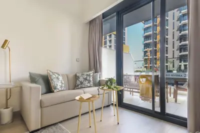 a living room with a couch and a large window at Frank Porter - Riviera 26 in Dubai
