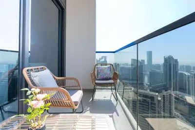 two chairs and a table on the balcony of a building at Mystic - Act One Tower in Dubai