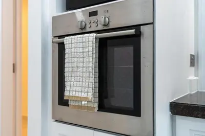 a kitchen oven with a towel on the door at Mystic - Fully Renovated Spacious 2BR Apt. with Burj Views in Dubai