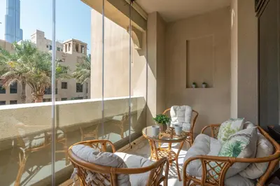 a balcony with chairs and a table and a window at Mystic - Fully Renovated Spacious 2BR Apt. with Burj Views in Dubai