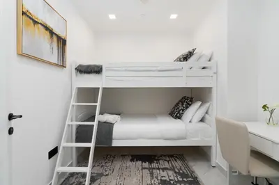 a room with two bunk beds and a desk at Mystic - Fully Renovated Spacious 2BR Apt. with Burj Views in Dubai