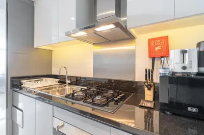 a kitchen with a sink and a stove at Mystic - Damac Maison Prive Tower B in Dubai