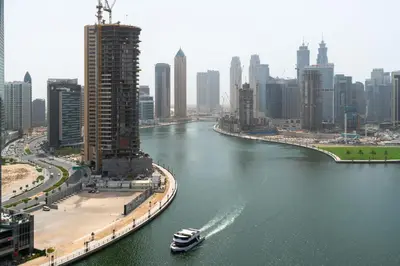 a boat traveling down a river in a city at Mystic - Damac Maison Prive Tower B in Dubai