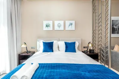 a bedroom with a blue and white bed with blue pillows at Mystic - Damac Maison Prive Tower A in Dubai