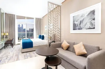 a living room with a couch and a bed at Mystic - Damac Maison Prive Tower A in Dubai