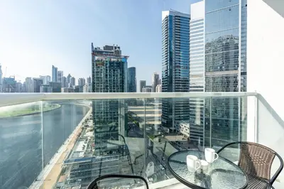 a balcony with a table and chairs and a view of the city at Mystic - Damac Maison Prive Tower A in Dubai