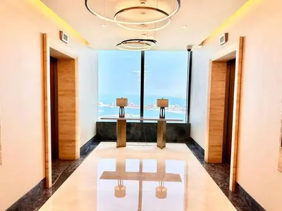 a hallway with two benches in front of a large window at Luxury Studio in High Floor Full Sea View in The Palm Tower Plam Jumeirah in Dubai