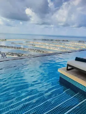 a large swimming pool with a view of the ocean at Luxury Studio in High Floor Full Sea View in The Palm Tower Plam Jumeirah in Dubai