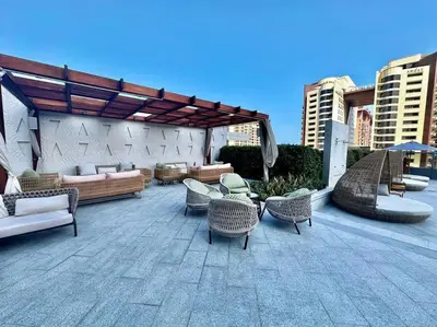 a patio with wicker chairs and tables and a pavilion at Luxury Studio in High Floor Full Sea View in The Palm Tower Plam Jumeirah in Dubai