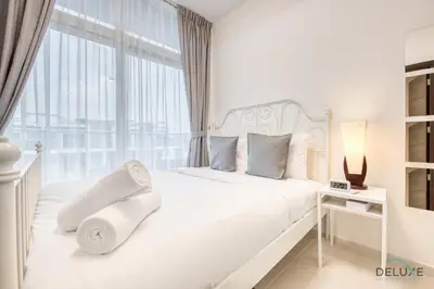 a white bedroom with a white bed and a window at Tranquil 3BR Townhouse at Albizia Damac Hills 2 by Deluxe Holiday Homes in Dubai