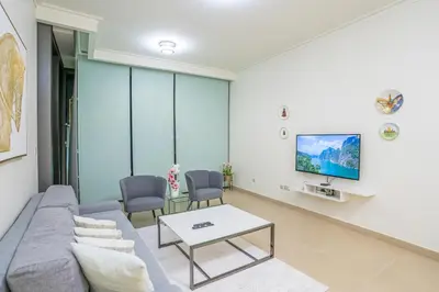 a living room with a couch and a tv at Vacay Lettings - Stunning Burj Khalifa fountain view near Dubai mall in Dubai