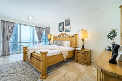 a bedroom with a wooden bed and a large window at Sophisticated 3BR w/ Assistant’s Room at Al Fattan Marine Towers 2 JBR by Deluxe Holiday Homes in Dubai