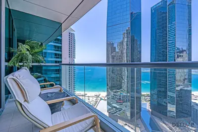 a balcony with a chair and a view of the ocean at Sophisticated 3BR w/ Assistant’s Room at Al Fattan Marine Towers 2 JBR by Deluxe Holiday Homes in Dubai