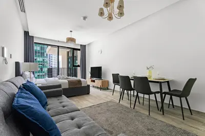 a living room with a couch and a dining room at StoneTree - Modern Studio - Special Offer! in Dubai
