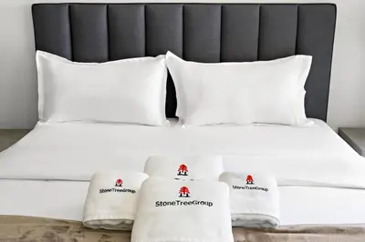 a white bed with white pillows and towels on it at StoneTree - Modern Studio - Special Offer! in Dubai
