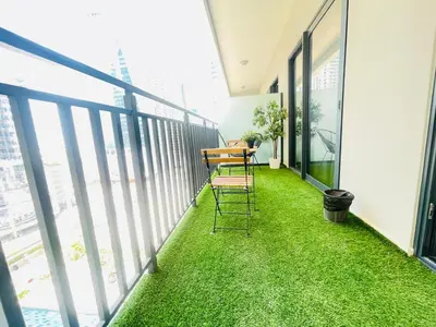 a balcony with green grass and a table and chairs at Pool View One Bed Room Business Bay in Dubai