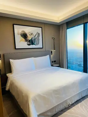 a large white bed in a hotel room with a window at The Address Residences Dubai Opera in Dubai