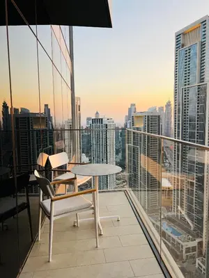 a table and chairs on a balcony with a view of a city at The Address Residences Dubai Opera in Dubai