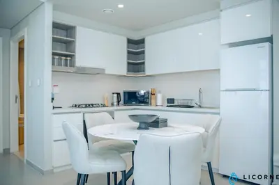 a white kitchen with a white table and chairs at Unveil Downtown Luxury, 1BR Majestic Skyline Views - Downtown Views ll in Dubai