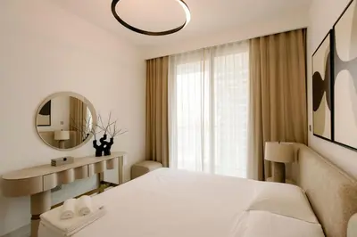 a white bedroom with a large bed and a mirror at Beachfront Elegant 2BD Condo with Breathtaking Views -15AB01 in Dubai