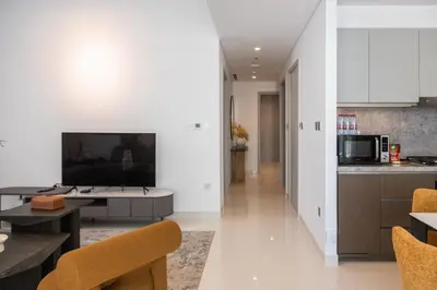 a kitchen and living room with a television and a table at Beachfront Elegant 2BD Condo with Breathtaking Views -15AB01 in Dubai
