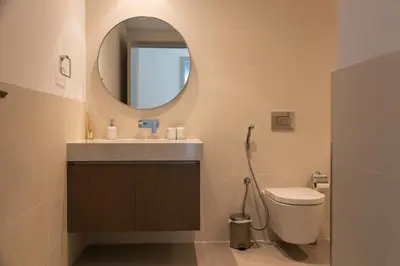 a bathroom with a sink and a toilet and a mirror at Beachfront Elegant 2BD Condo with Breathtaking Views -15AB01 in Dubai