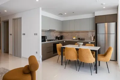 a kitchen with a table and chairs and a refrigerator at Beachfront Elegant 2BD Condo with Breathtaking Views -15AB01 in Dubai