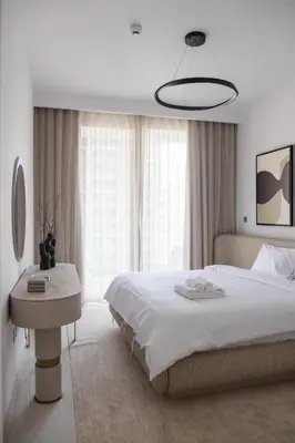 a white bedroom with a large bed and a table at Beachfront Elegant 2BD Condo with Breathtaking Views -15AB01 in Dubai