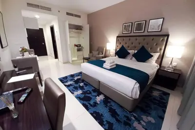 a bedroom with a large bed and a table and a room at StoneTree - Furnished Studio - Celestia B in Dubai