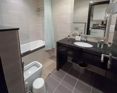 a bathroom with a sink and a tub and a toilet at StoneTree - Furnished Studio - Celestia B in Dubai