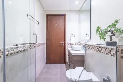 a bathroom with a toilet and a sink and a shower at TruStay Vacation Home Rentals - Business Bay in Dubai