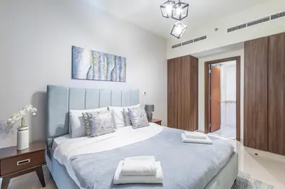 a bedroom with a large bed with a blue headboard at TruStay Vacation Home Rentals - Business Bay in Dubai