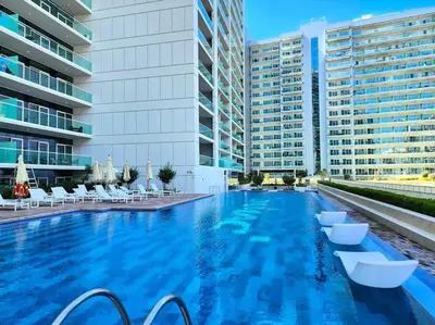 a large swimming pool with white chairs and buildings at TruStay Vacation Home Rentals - Business Bay in Dubai