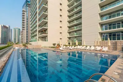 a large swimming pool in front of a building at TruStay Vacation Home Rentals - Business Bay in Dubai