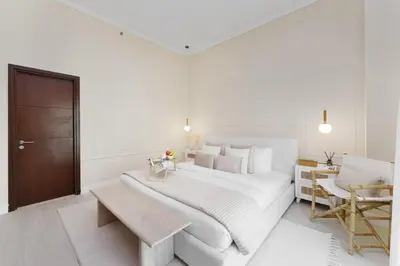 a white bedroom with a large bed and a desk at Maison Privee - Modern Beach Living in the Heart of Dubai Marina in Dubai