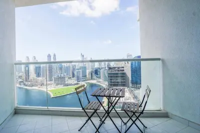 two chairs and a table on a balcony with a view at Stunning 1 BR Damac Maison Prive in Dubai